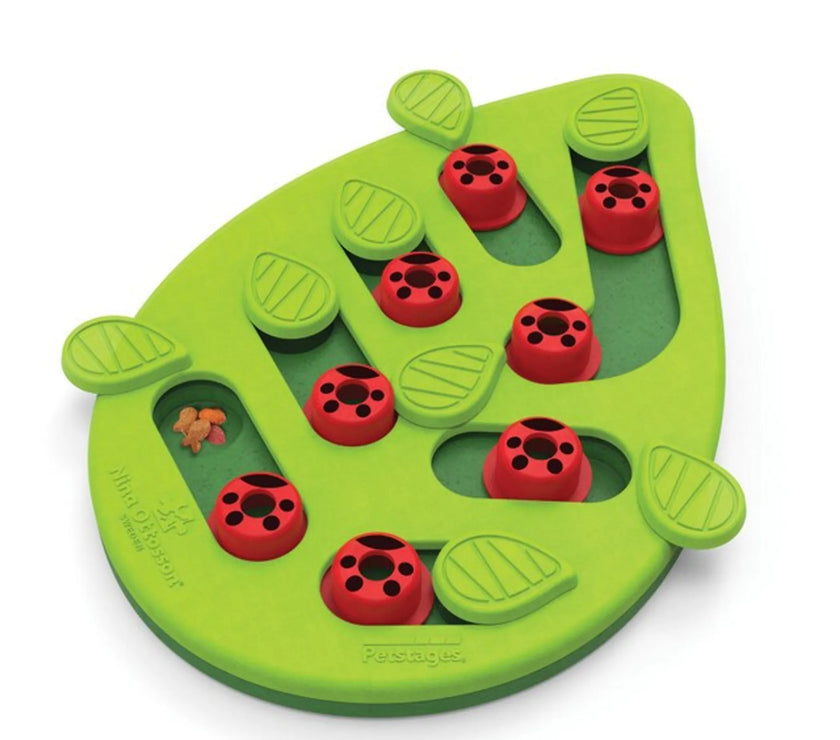 Green leaf-shaped Catstages Puzzle Toy with red peg covers and hidden treat compartments for interactive cat play and feeding